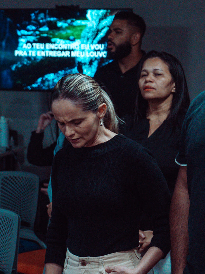 Mulher em oração durante um culto da Igreja Redenção na Avenida Paulista